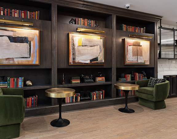 the lobby of a hotel with chairs and bookshelves at The Madison, Columbus
