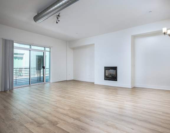 an empty living room with white walls and a fireplace