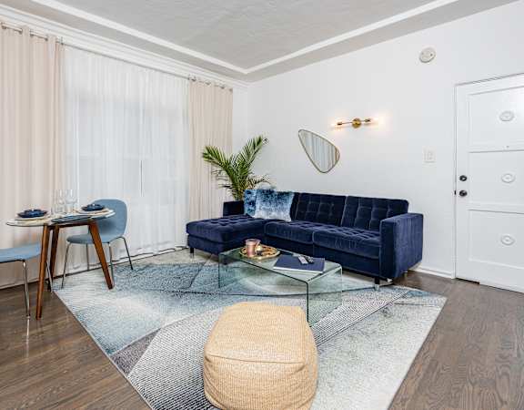 a living room with a blue couch and a glass coffee table