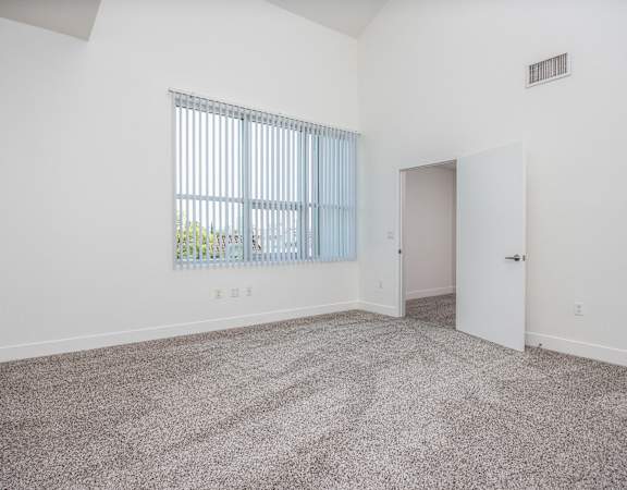 an empty living room with carpet and a window