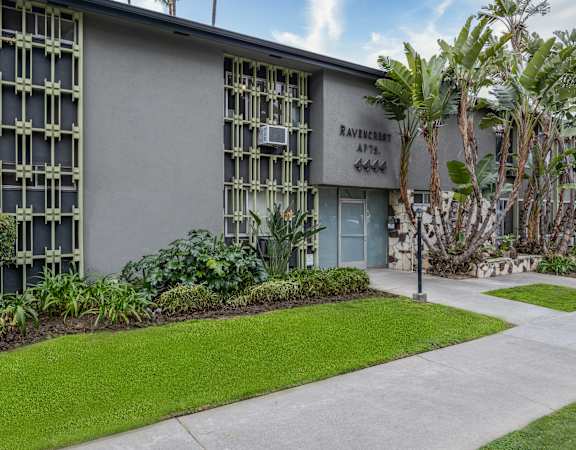 a building with a lawn and trees in front of it