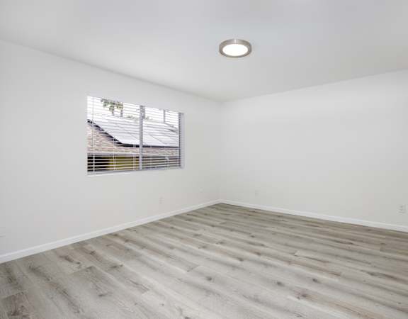 an empty room with white walls and a window