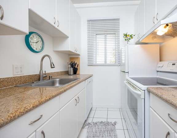 a kitchen with white cabinets and granite countertops