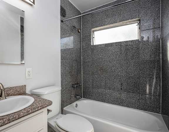 A bathroom with a sink, toilet, and bathtub.