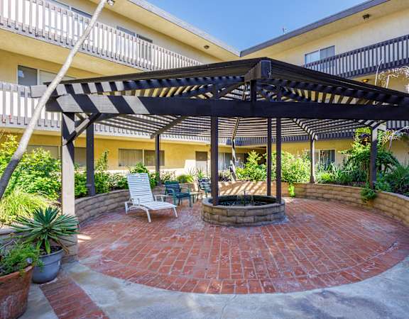 a patio with a fire pit and a gazebo