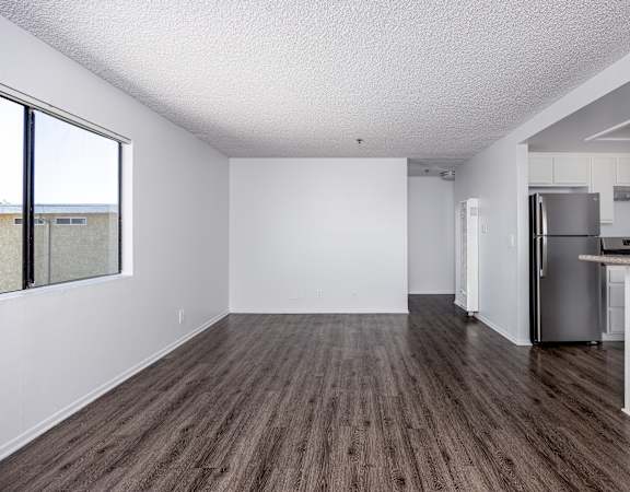 A kitchen with white cabinets and a refrigerator.