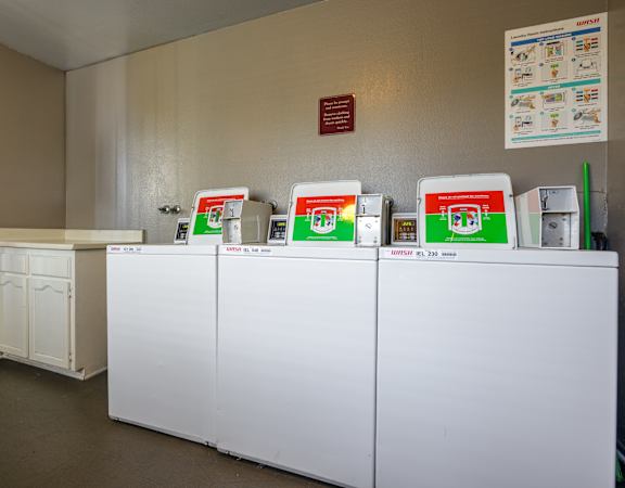 A row of washing machines are lined up in a laundromat.