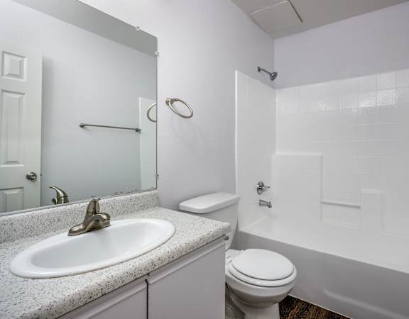A white bathroom with a sink, toilet, and bathtub.