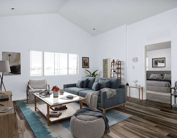 A living room with a grey couch and a wooden coffee table.