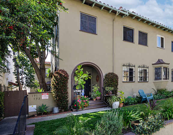 a house with an arched doorway and a garden outside of it