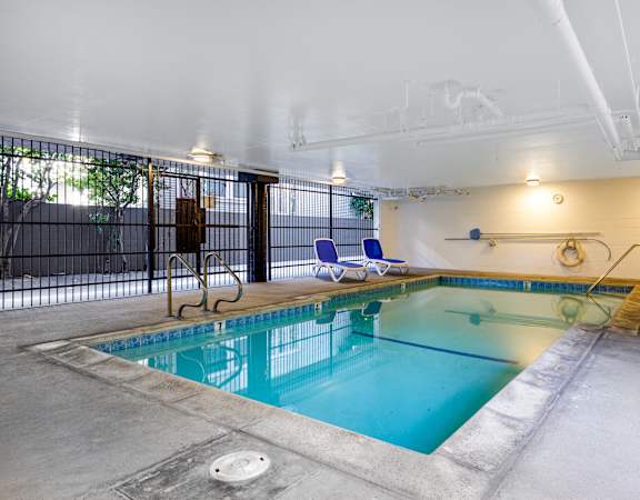 a swimming pool with chairs and a fence around it