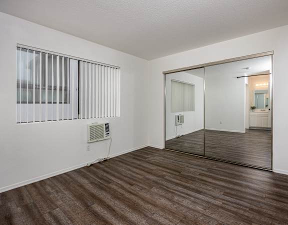 A room with a wooden floor and a sliding glass door.