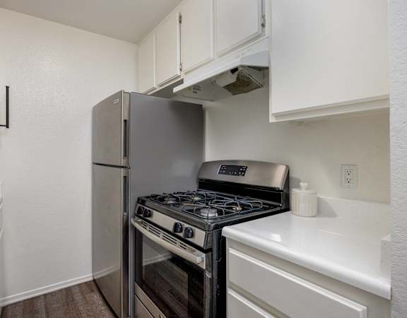 A kitchen with a stove and a refrigerator.