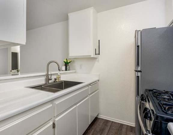 A kitchen with white cabinets and a black stove.