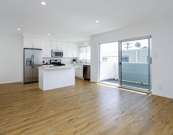 a living room with a kitchen and a sliding glass door