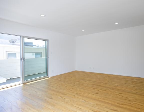 a living room with white walls and a sliding glass door