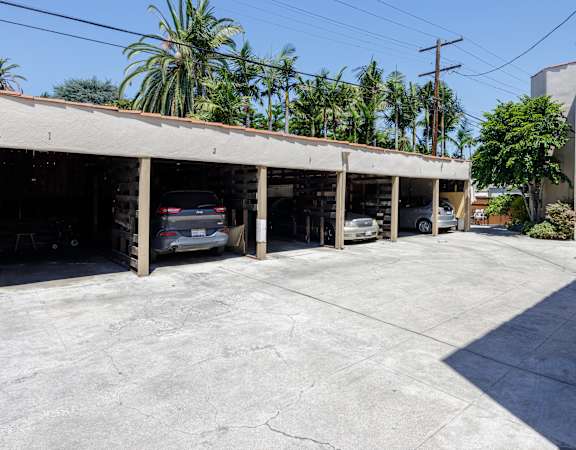 a parking garage with cars in it and palm trees