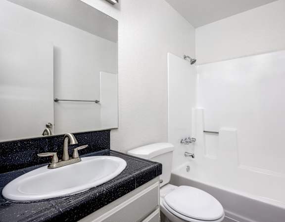 A white toilet sits next to a sink in a bathroom.