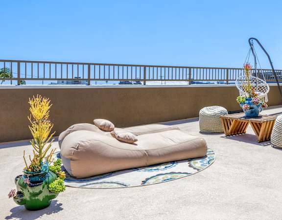 a terrace with a bean bag chair and tables on a roof