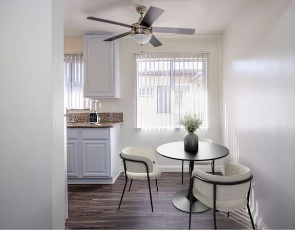 a kitchen and dining area with a table and chairs and a ceiling fan