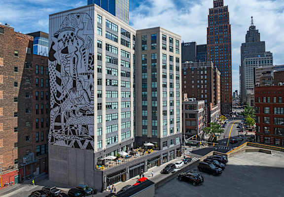 A large mural of a lion is on the side of a building at 28Grand, Detroit, MI