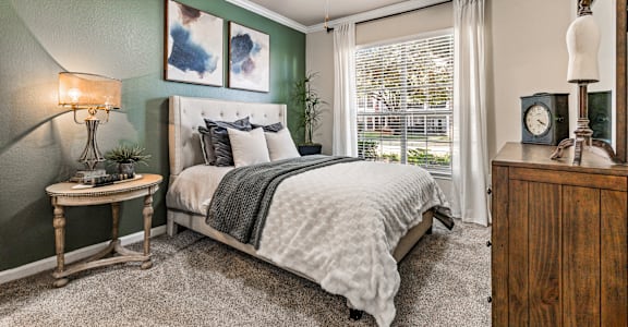 A bedroom with a bed, nightstand, and a ceiling fan.