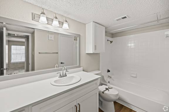 A white bathroom with a sink, toilet, and bathtub. at Highland Park, Texas, 76132