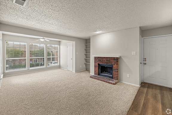 A living room with a fireplace and sliding glass doors. at Highland Park, Texas, 76132