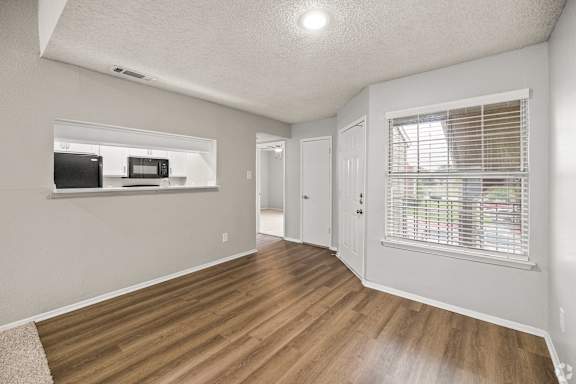 A room with a wooden floor and a window with blinds. at Highland Park, Texas, 76132