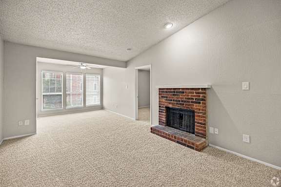 A living room with a fireplace and a carpeted floor. at Highland Park, Texas, 76132