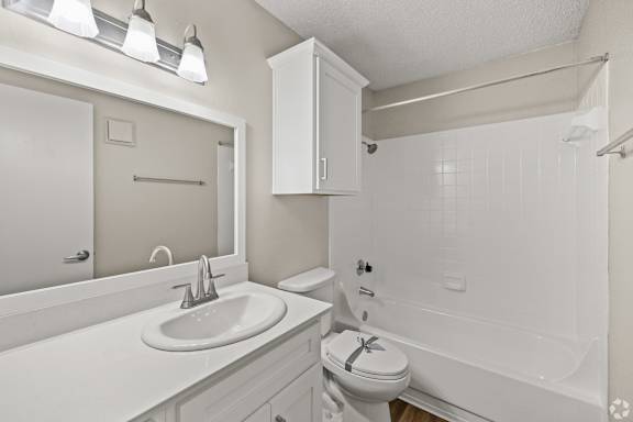 A white bathroom with a sink, toilet, and bathtub. at Highland Park, Texas, 76132