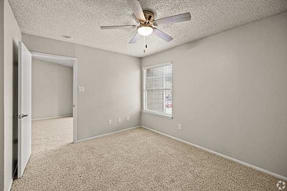 A room with a ceiling fan and carpeted floor. at Highland Park, Texas, 76132