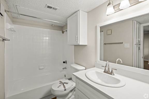 A white bathroom with a toilet, sink, and bathtub. at Highland Park, Texas, 76132
