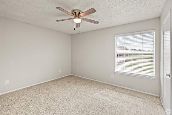 A room with a ceiling fan and a window with blinds. at Highland Park, Texas, 76132