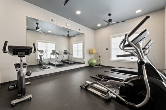 gym with exercise equipment at the district flats apartments in lenexa at Sandy Creek Apartments, Bryan, TX