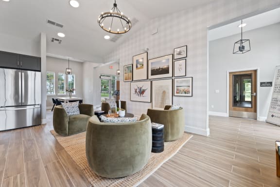 a living room with couches and chairs and a kitchen at Sandy Creek Apartments, Bryan