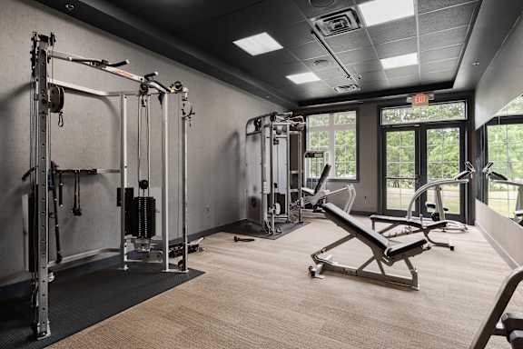 a gym with weights and equipment in a room with windows