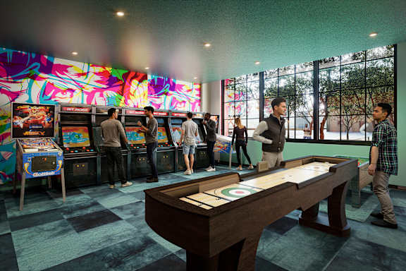 A group of people playing games in a room with a pool table.