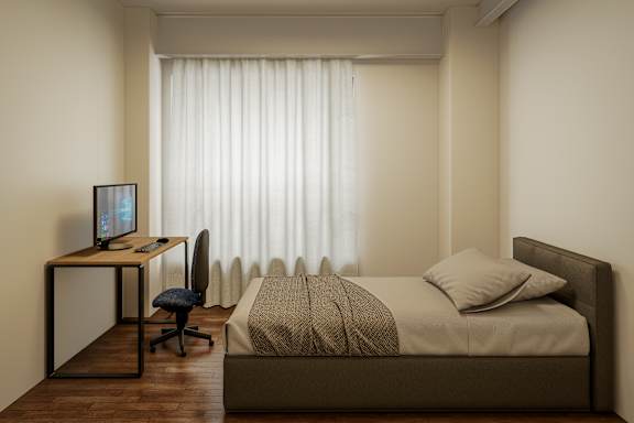 A bedroom with a bed, desk, and chair.