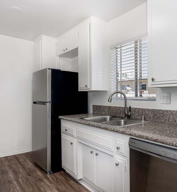 A kitchen with white cabinets and a granite countertop.
