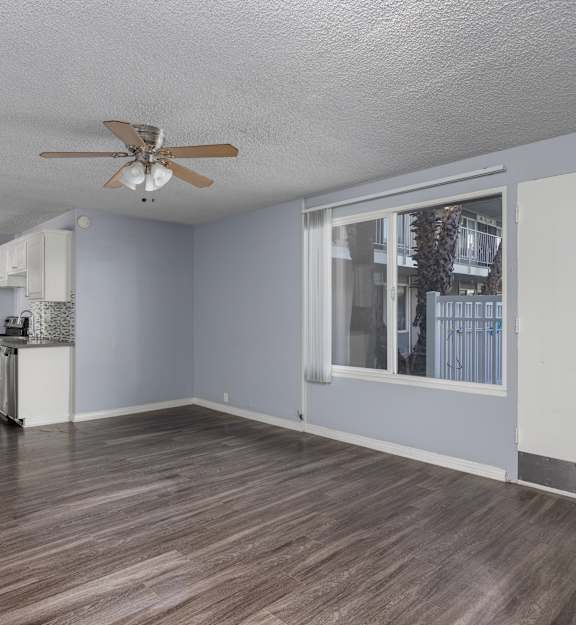 A room with a ceiling fan and sliding glass doors.