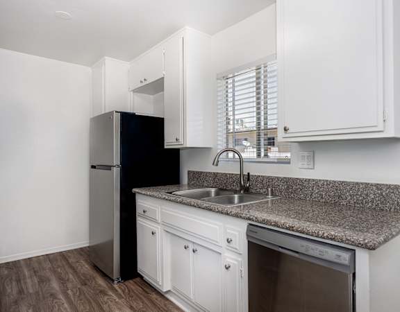 A kitchen with white cabinets and a granite countertop.