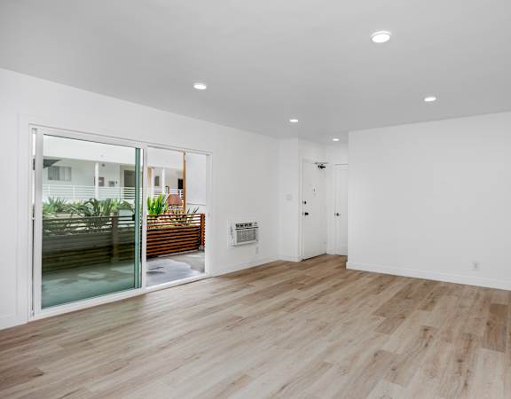 A room with wooden flooring and white walls.