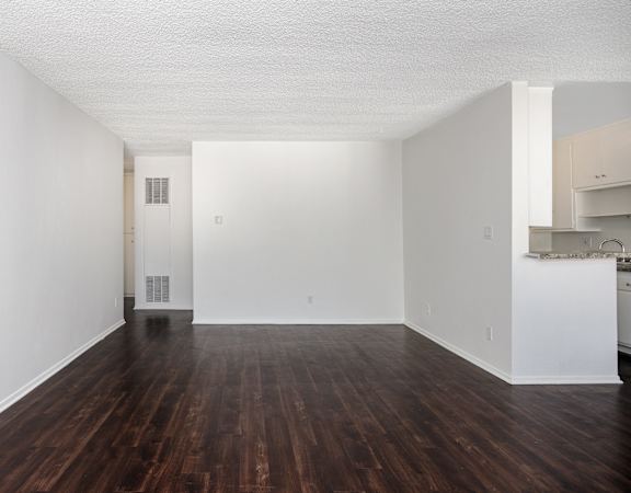 an empty living room with white walls and wood floors