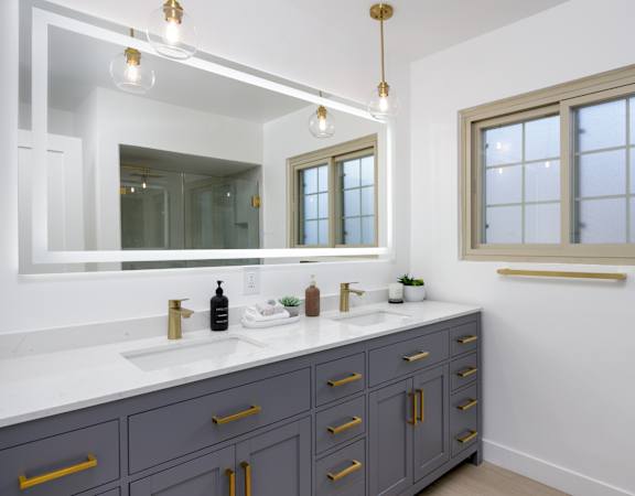a white bathroom with two sinks and a mirror