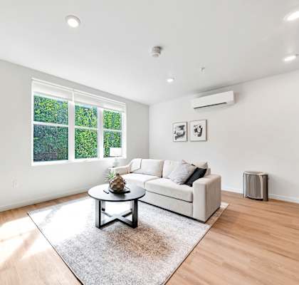 A living room with a white couch and a coffee table.