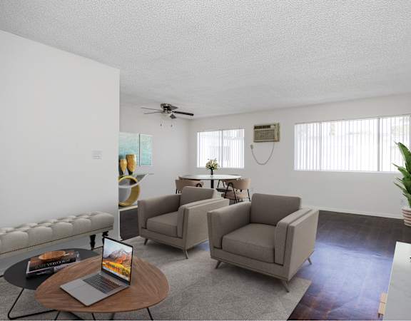 a living room with couches and chairs and a table with a laptop