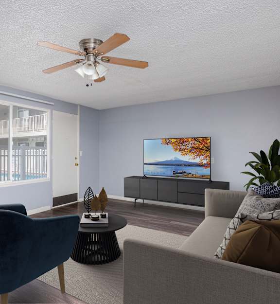 A room with a ceiling fan and wooden flooring.
