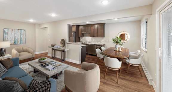 A modern living room with a dining area and kitchen in the background.