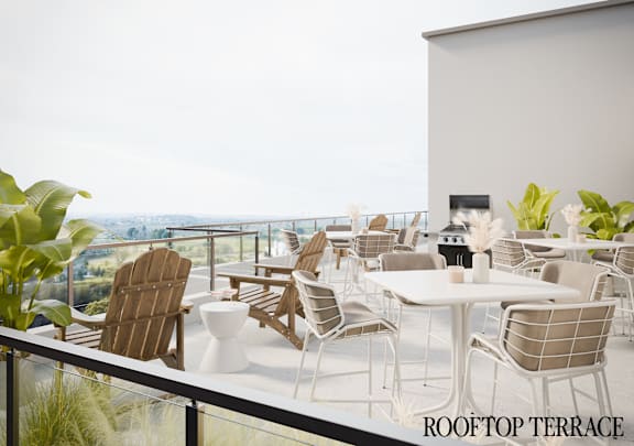 A rooftop terrace with a table and chairs overlooking a scenic view.